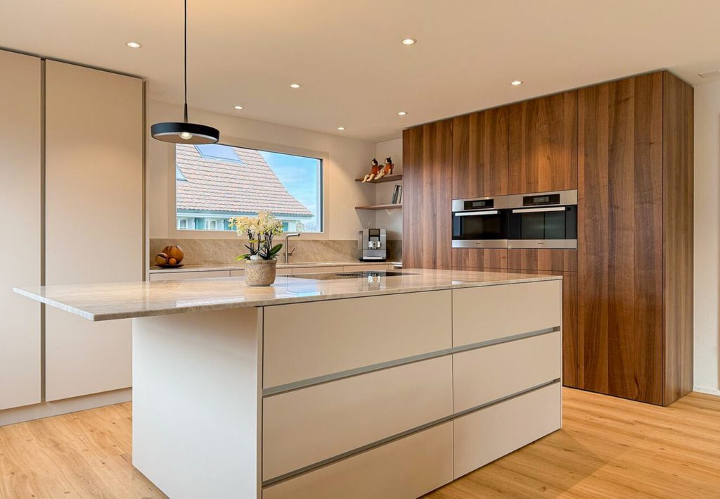 Moderne Küche mit Holzfronten und Kochinsel von wargerbösch ag in Amriswil
